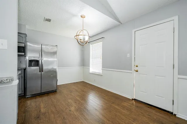 a view of a kitchen with a sink refrigerator and wooden floor