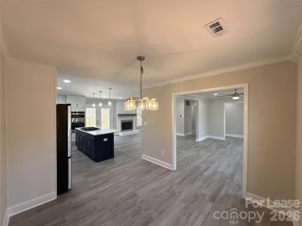 a view of a kitchen with wooden floor and a window