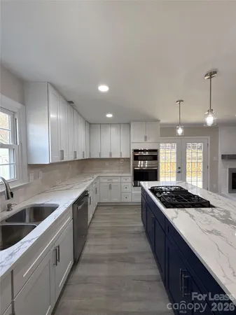 a kitchen with stainless steel appliances kitchen island a stove and a sink