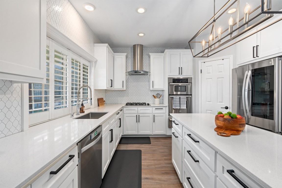 a kitchen with stainless steel appliances a stove refrigerator sink and cabinets