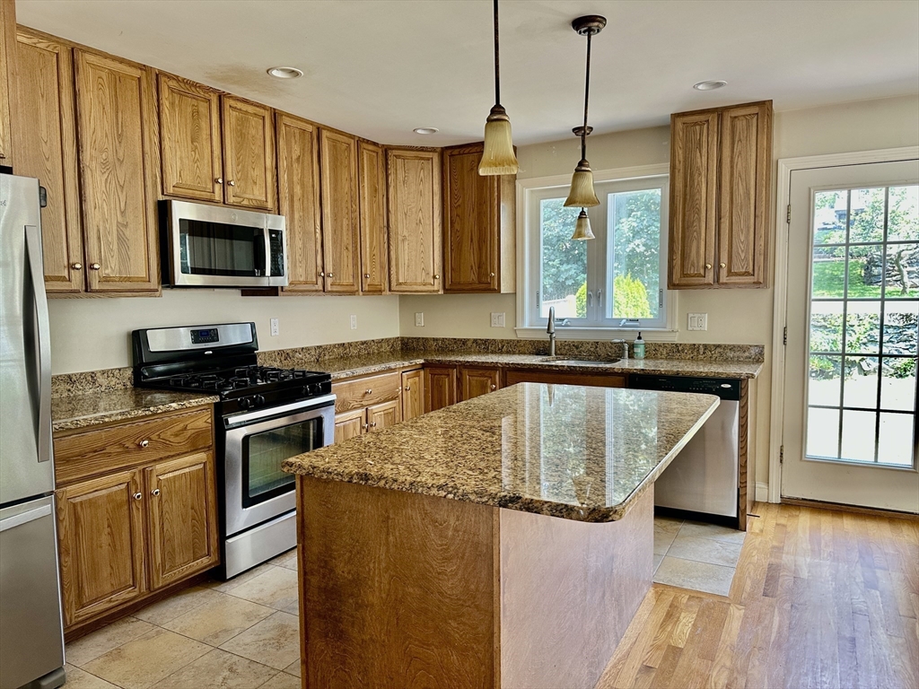 183 Summer Street, Unit 183 Watertown, MA 02472 - Photo 2 of 12 a kitchen with stainless steel appliances granite countertop a sink a stove and a wooden cabinets
