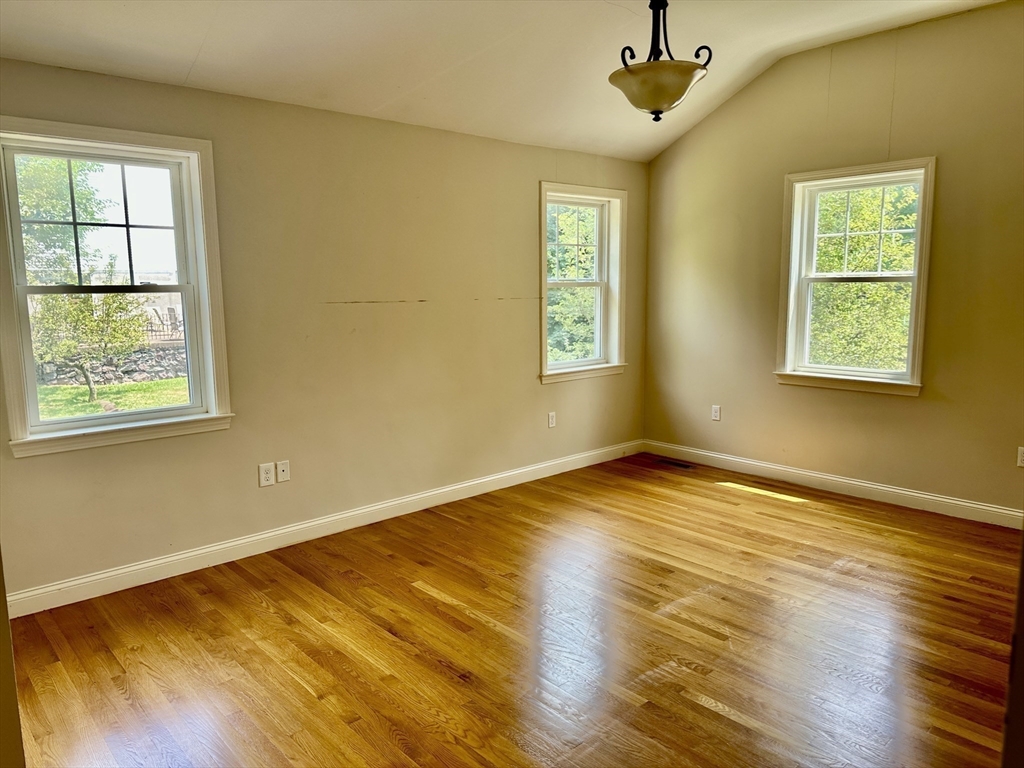 183 Summer Street, Unit 183 Watertown, MA 02472 - Photo 5 of 12 a view of an empty room with wooden floor and a window