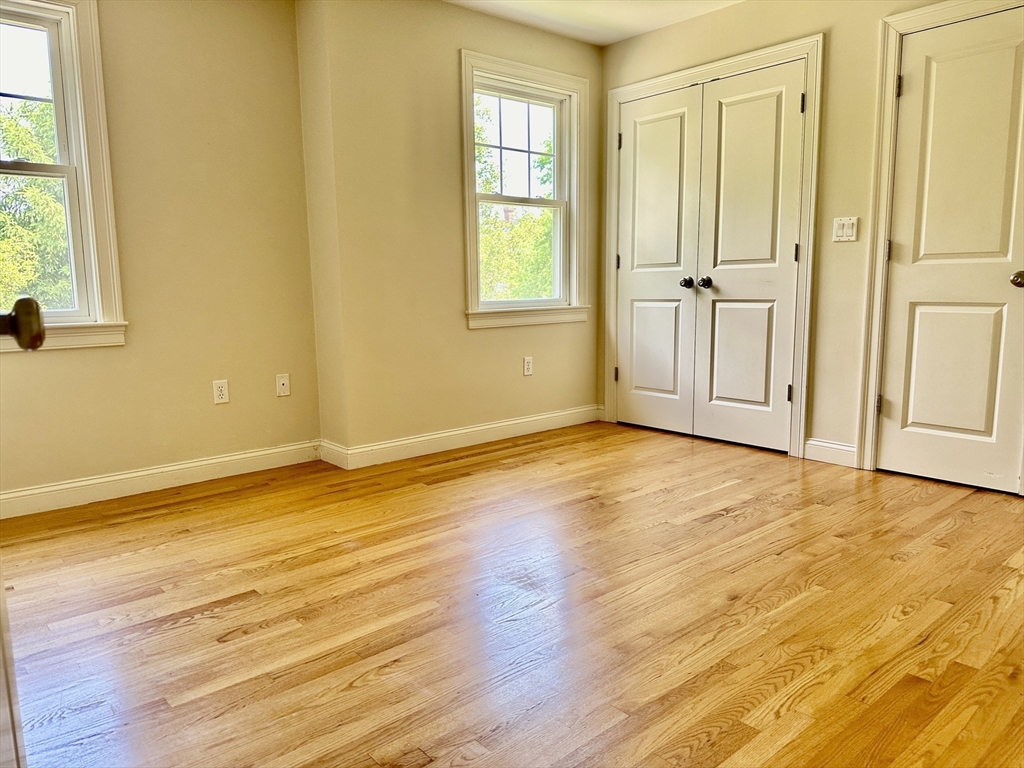 183 Summer Street, Unit 183 Watertown, MA 02472 - Photo 8 of 12 a view of an empty room with wooden floor and a window