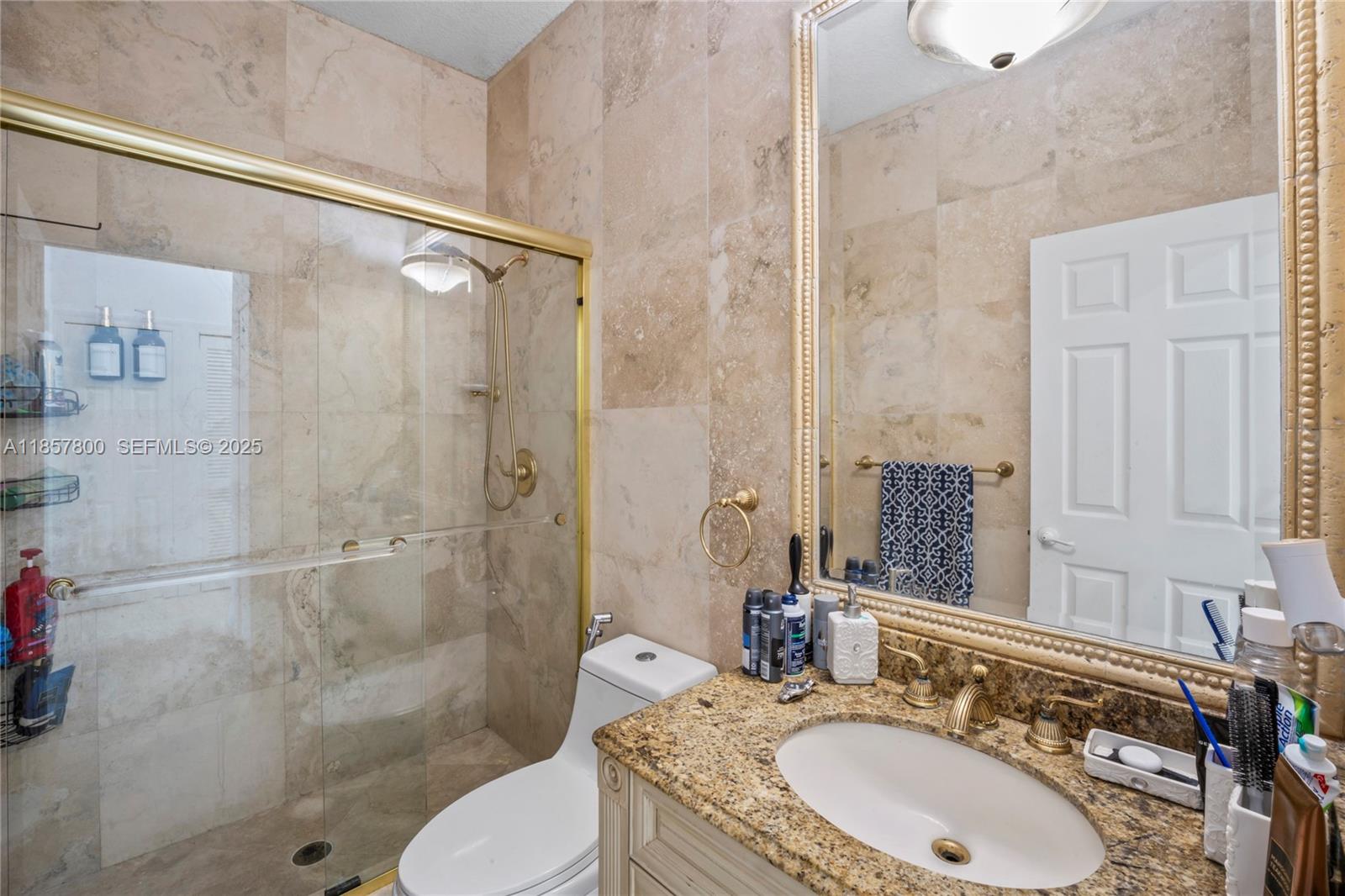 5750 Southwest 67th Avenue Miami, FL 33143 - Photo 19 of 62 a bathroom with a granite countertop sink toilet and shower