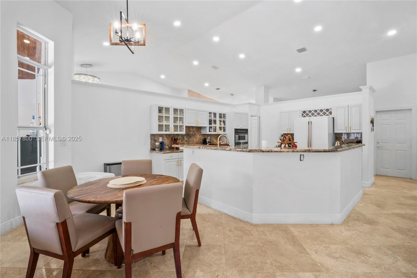 5750 Southwest 67th Avenue Miami, FL 33143 - Photo 26 of 62 a dining room with kitchen island stainless steel appliances furniture a chandelier and kitchen view