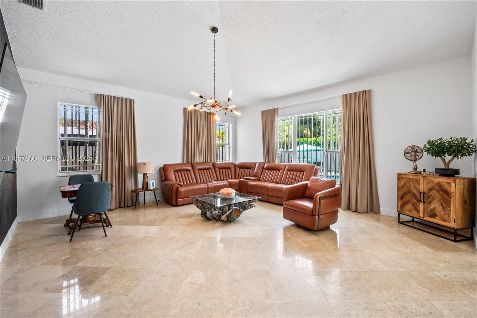 5750 Southwest 67th Avenue Miami, FL 33143 - Photo 28 of 62 a living room with furniture and a chandelier