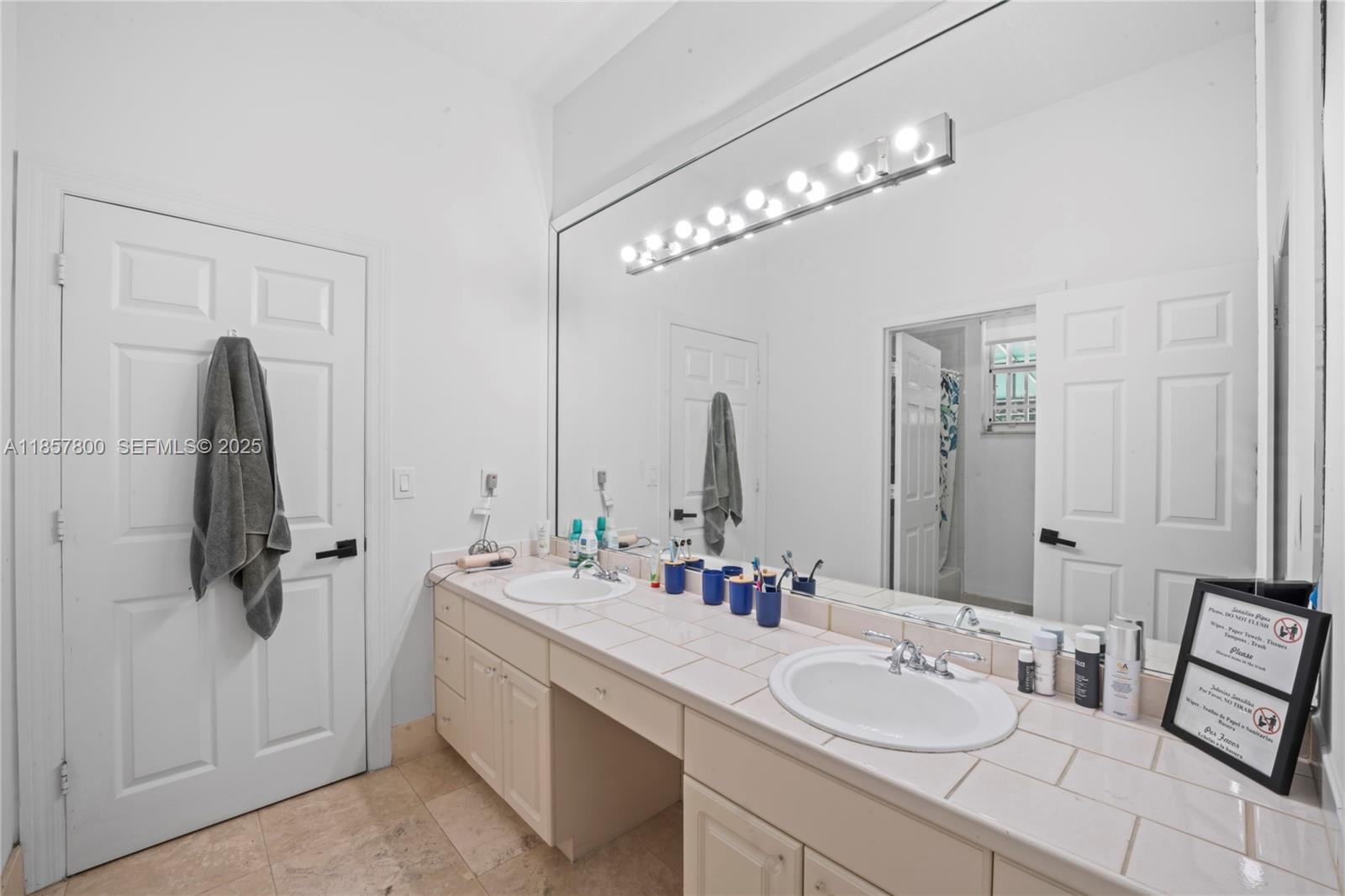 5750 Southwest 67th Avenue Miami, FL 33143 - Photo 38 of 62 a bathroom with a double vanity sink mirror and shower
