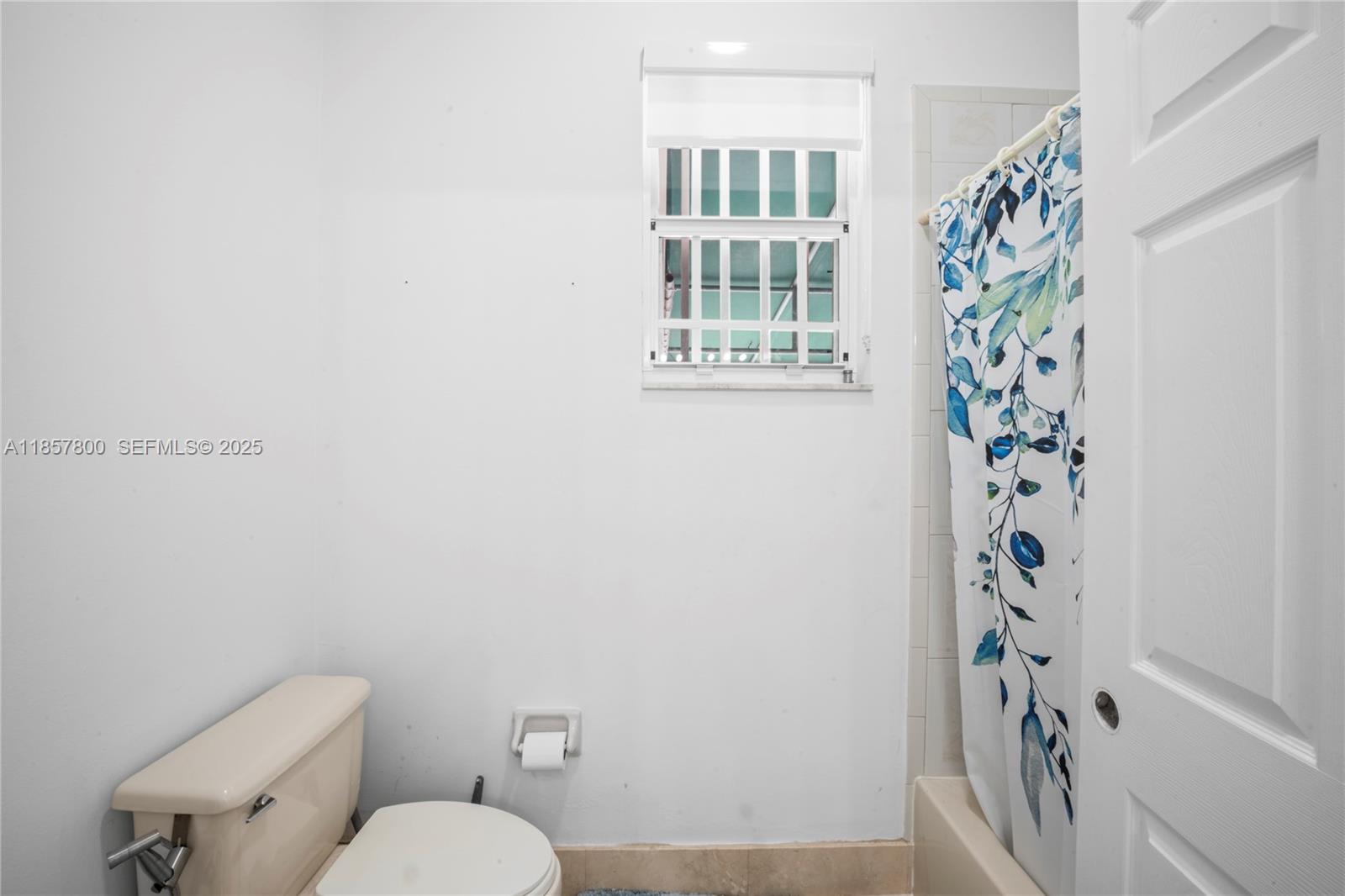 5750 Southwest 67th Avenue Miami, FL 33143 - Photo 39 of 62 a bathroom with a toilet and a shower curtain