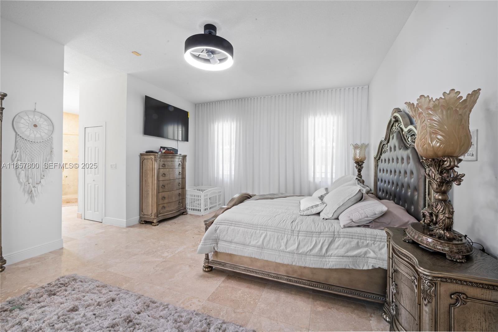 5750 Southwest 67th Avenue Miami, FL 33143 - Photo 44 of 62 a bedroom with a bed and a chandelier