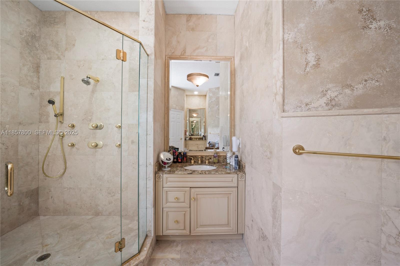 5750 Southwest 67th Avenue Miami, FL 33143 - Photo 51 of 62 a bathroom with a granite countertop shower a mirror and a sink