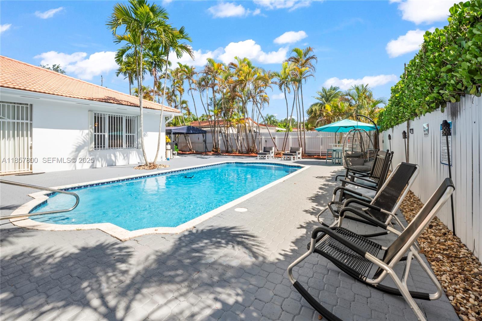 5750 Southwest 67th Avenue Miami, FL 33143 - Photo 62 of 62 swimming pool with outdoor seating and trees in the background