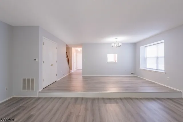 an empty room with wooden floor and window