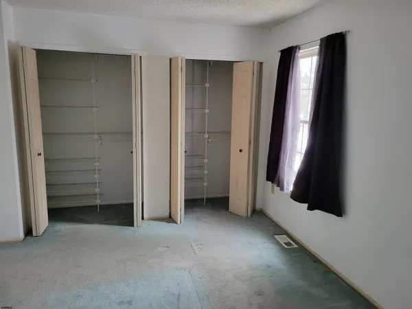 an empty room with a fireplace and windows