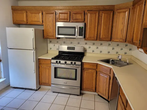 a kitchen with stainless steel appliances a refrigerator stove and microwave