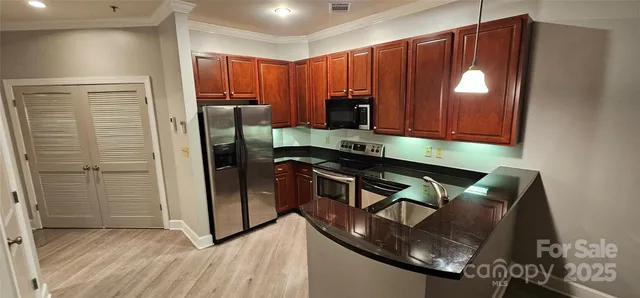 a kitchen with stainless steel appliances granite countertop a sink refrigerator and cabinets