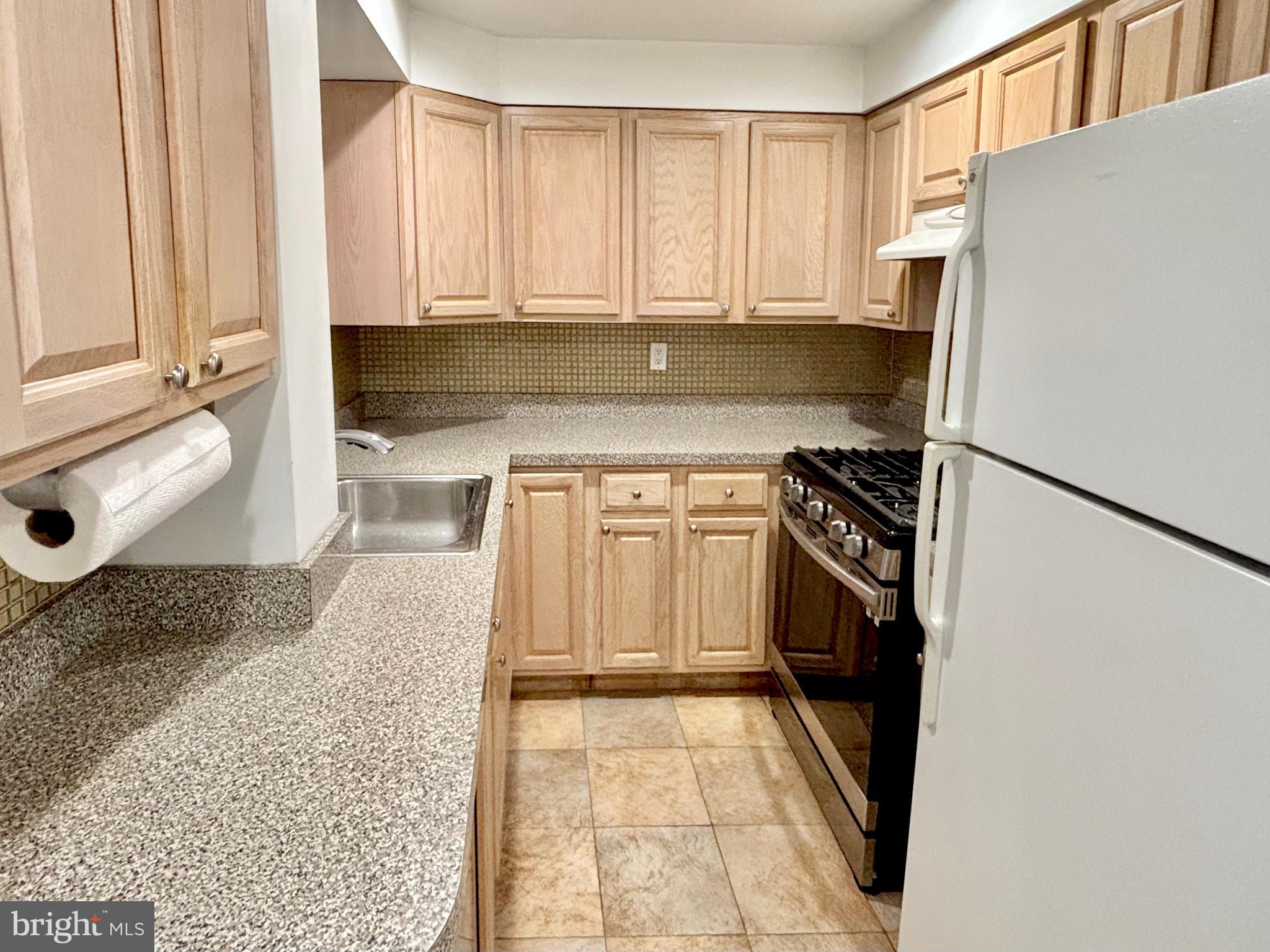 766 Martin Street Philadelphia, PA 19146 - Photo 13 of 35 a kitchen with a refrigerator stove and white cabinets