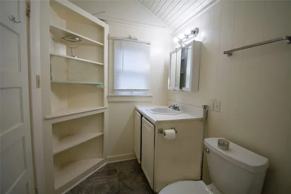 a bathroom with a toilet sink and mirror