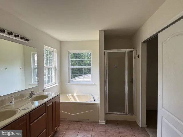 an empty room with ceiling fan and window