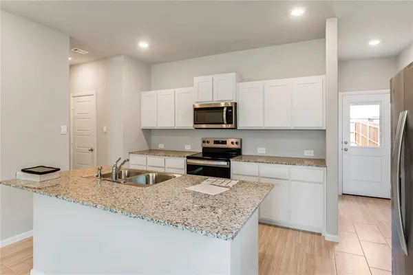 a kitchen with granite countertop a sink and a stove top oven