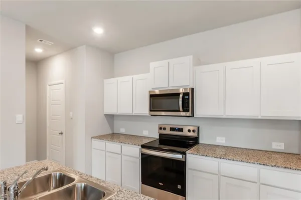 a kitchen with a sink and steel appliances