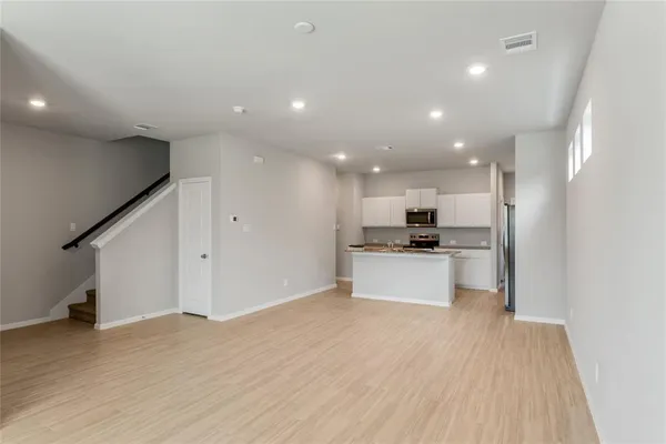 a view of kitchen with kitchen island stainless steel appliances wooden floor and window