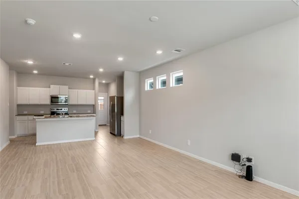 a kitchen with a refrigerator and a stove top oven