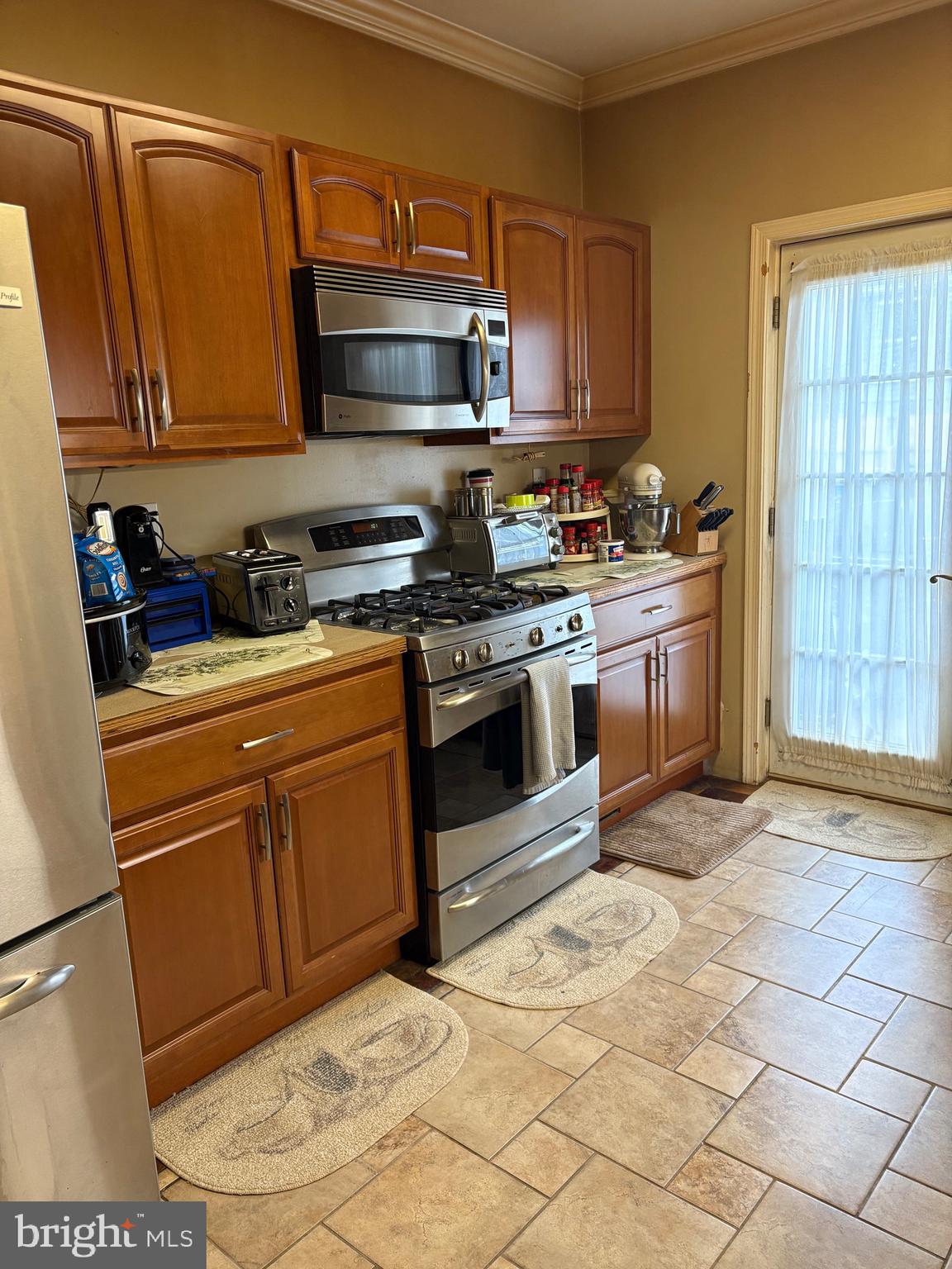 2713 Hampden Avenue Baltimore, MD 21211 - Photo 13 of 23 a kitchen with stainless steel appliances granite countertop a stove a sink and a microwave