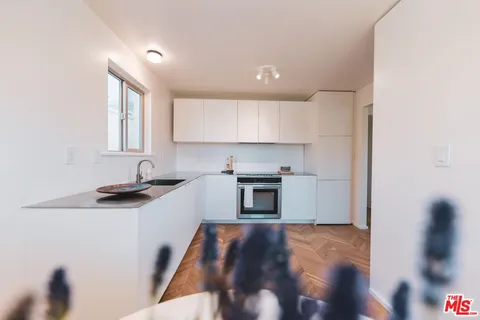 a kitchen with granite countertop a stove a sink and a microwave