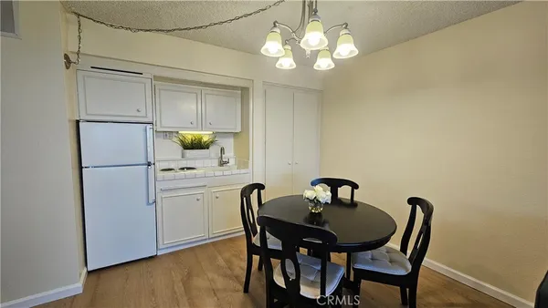 a kitchen with a table chairs and refrigerator