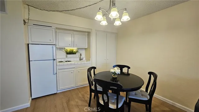 a kitchen with a table chairs and refrigerator
