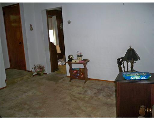 Living Room. You enter the livingroom from the front door. The carpeting is older but has hard wood flooring under it. This is a nice sized room.