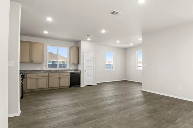 a kitchen with granite countertop a refrigerator and a stove top oven