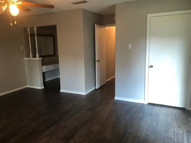 an empty room with wooden floor and closet