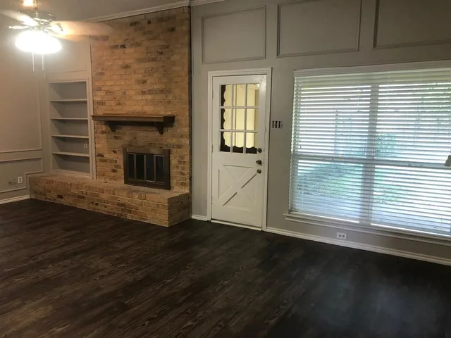 a view of a livingroom with wooden floor and a fireplace