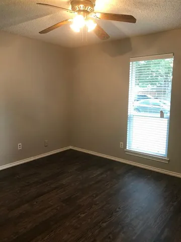 an empty room with wooden floor and windows in it