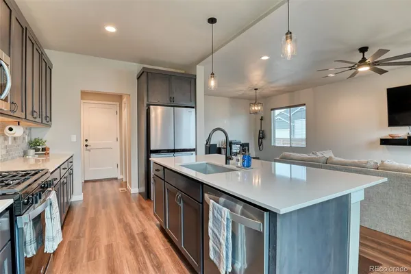 a kitchen with stainless steel appliances granite countertop a sink stove and wooden floor