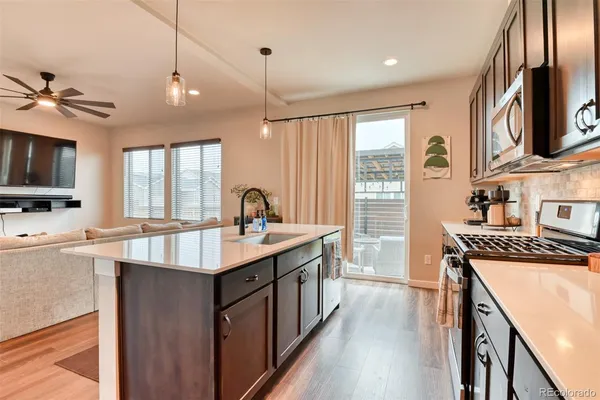 a kitchen with kitchen island granite countertop a sink stainless steel appliances and cabinets
