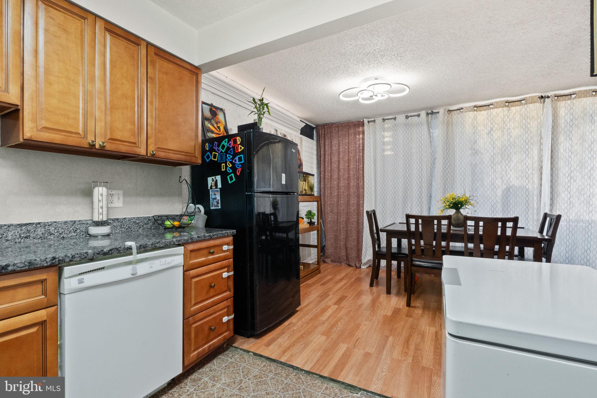1832 Metzerott Road, Unit 303 Adelphi, MD 20783 - Photo 11 of 22 a kitchen with stainless steel appliances granite countertop a stove a sink dishwasher and a refrigerator with wooden cabinets