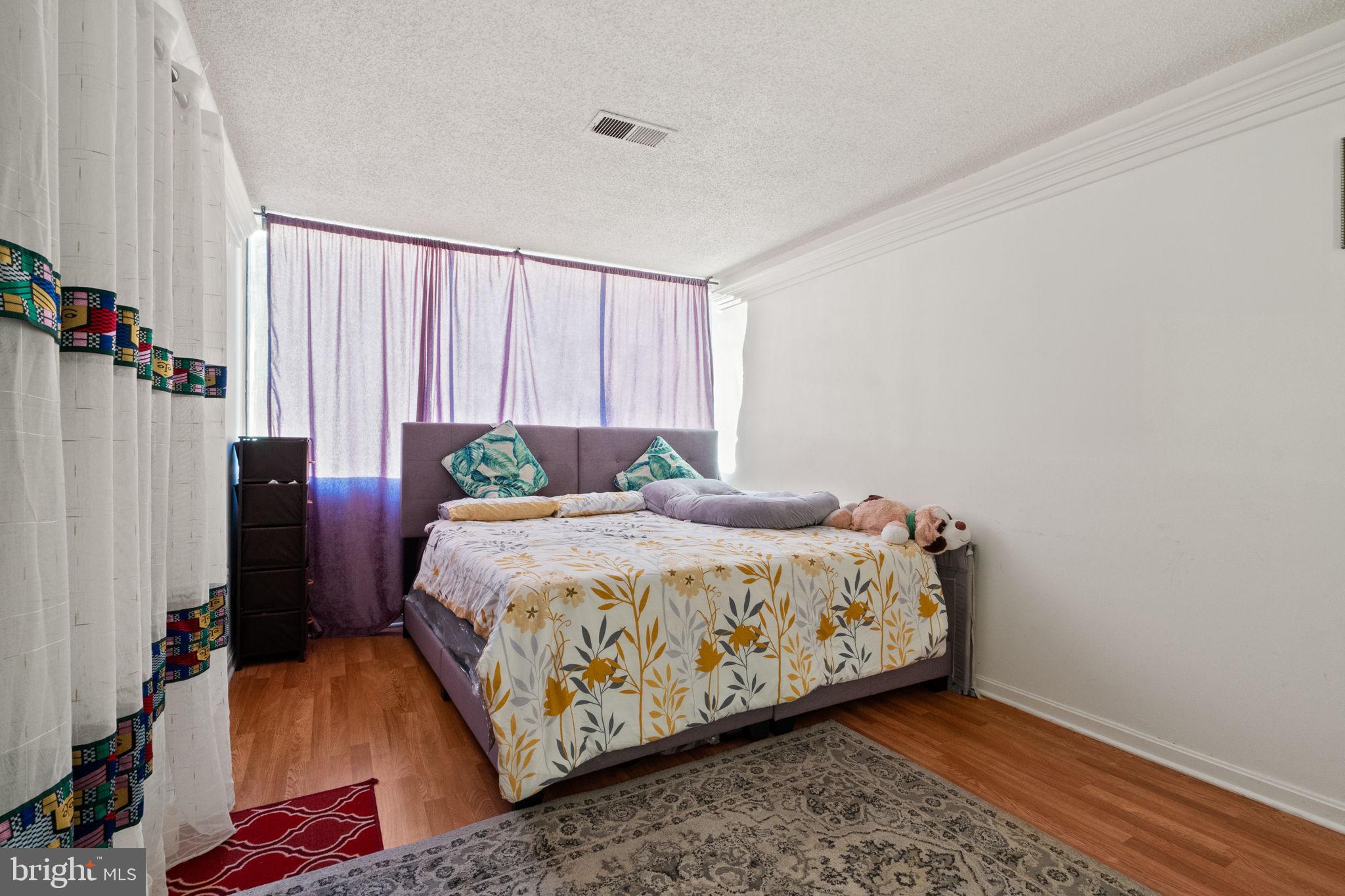 1832 Metzerott Road, Unit 303 Adelphi, MD 20783 - Photo 15 of 22 a bed sitting in a bedroom next to a window