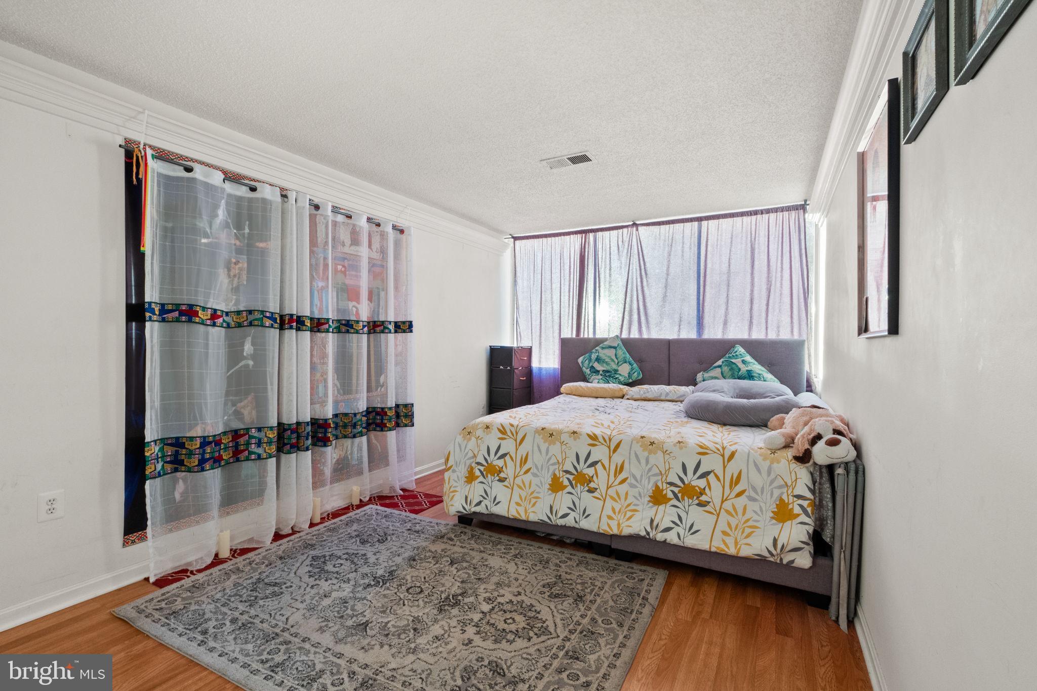 1832 Metzerott Road, Unit 303 Adelphi, MD 20783 - Photo 17 of 22 a bedroom with a bed and wooden floor