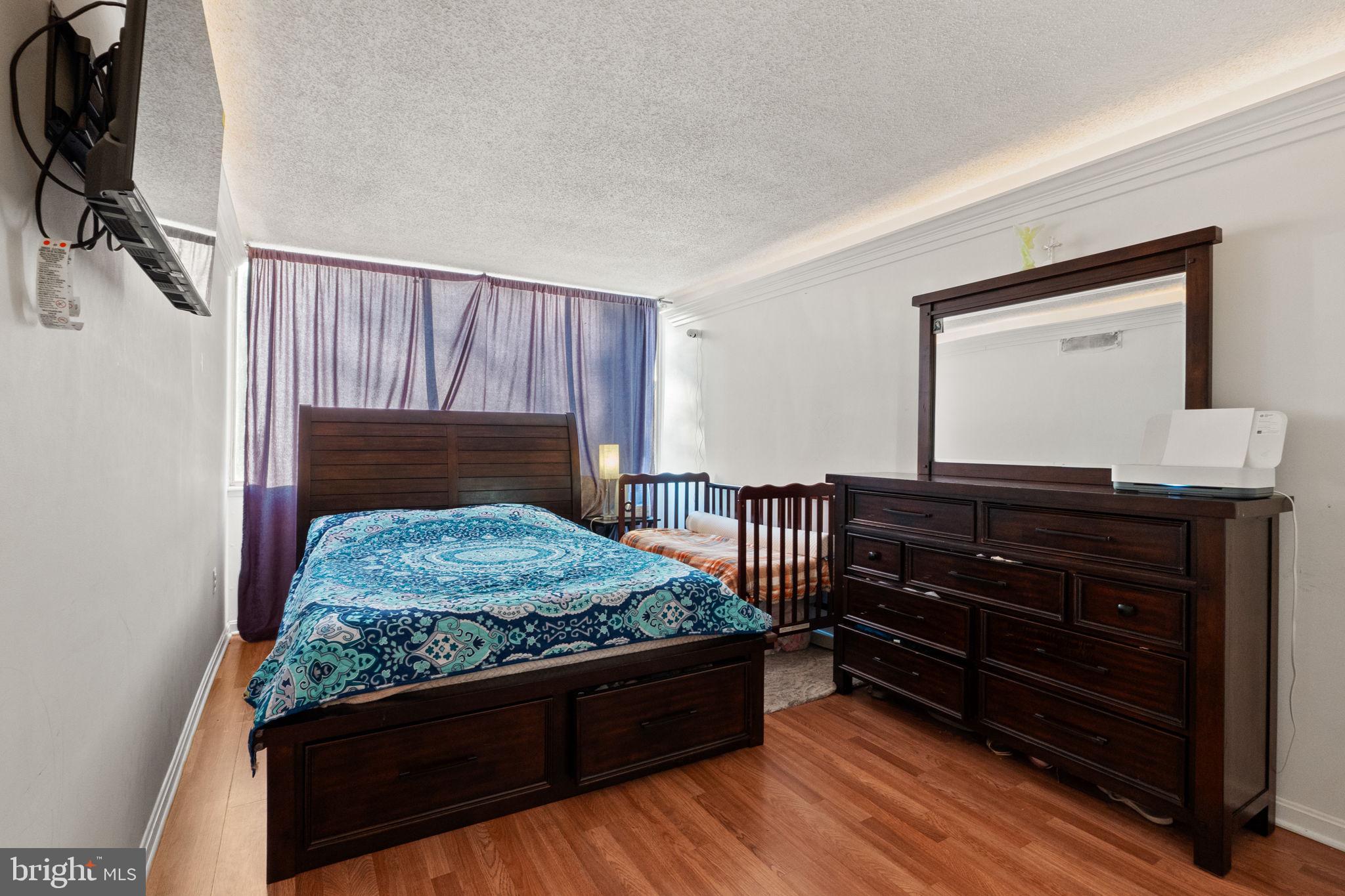 1832 Metzerott Road, Unit 303 Adelphi, MD 20783 - Photo 19 of 22 a bedroom with a bed and a dresser