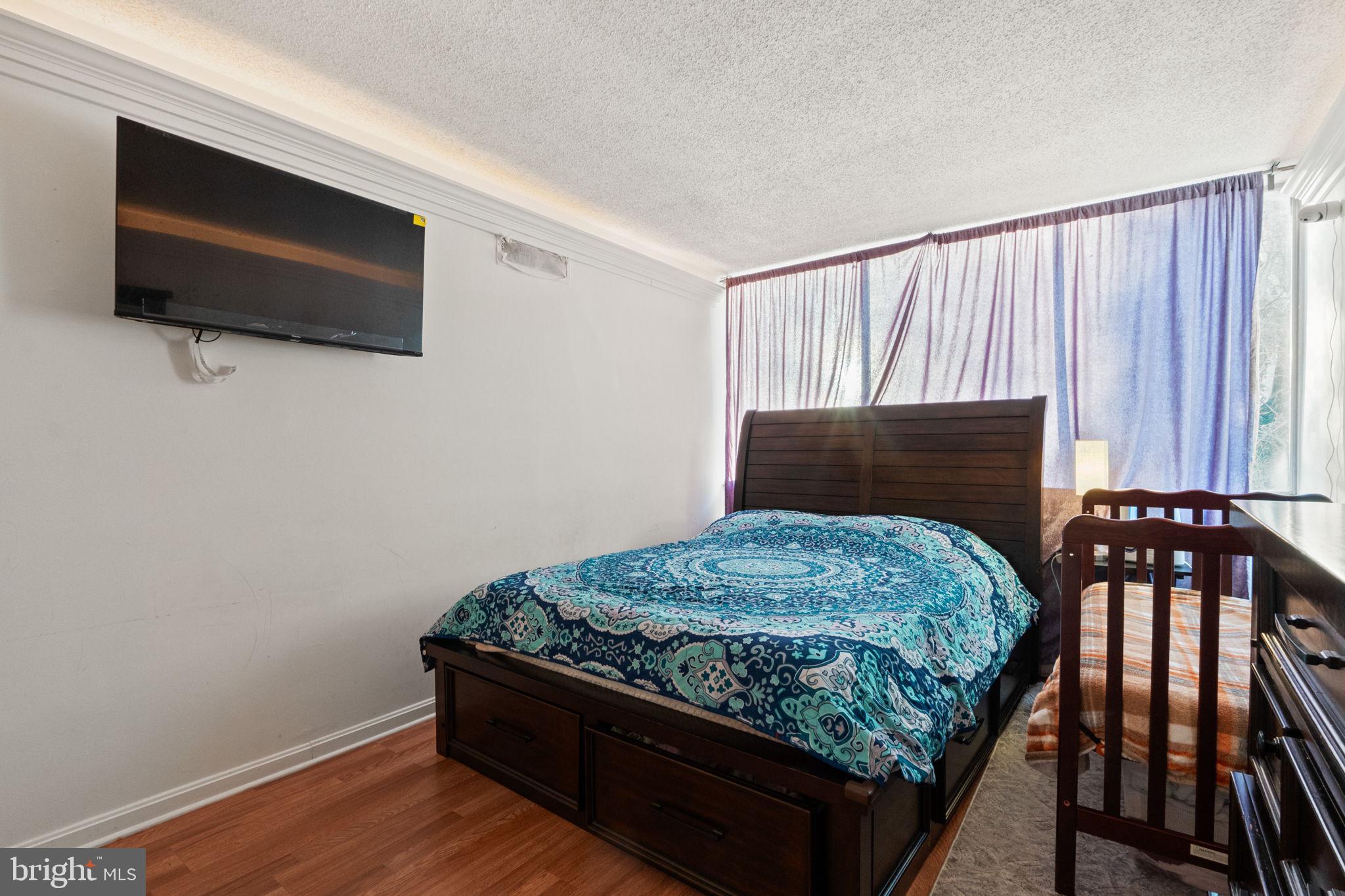 1832 Metzerott Road, Unit 303 Adelphi, MD 20783 - Photo 20 of 22 a bedroom with a bed and flat screen tv