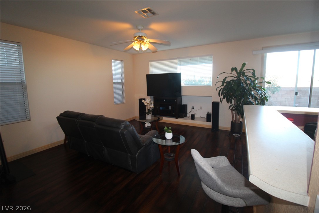 207 Priority Point Street Henderson, NV 89012 - Photo 8 of 23 Rich dark wood flooring anchors this comfortable living space adjoined by a breakfast bar.