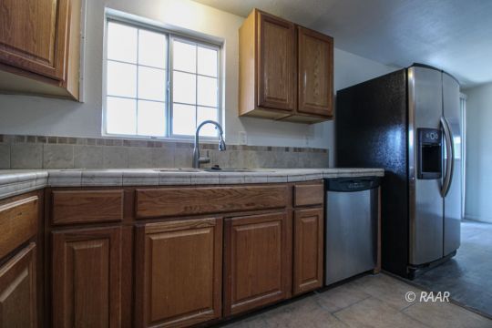 1645 Porter Street Ridgecrest, CA 93555 - Photo 13 of 35 a kitchen with stainless steel appliances granite countertop a refrigerator and a sink