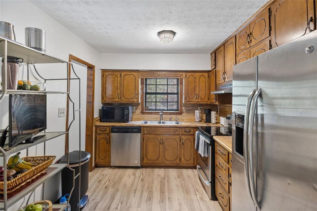 5865 Vernier Drive Southwest Atlanta, GA 30349 - Photo 11 of 33 a kitchen with stainless steel appliances a refrigerator stove and sink