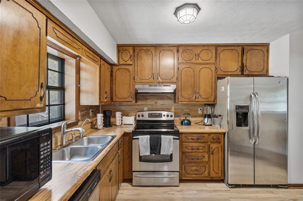 5865 Vernier Drive Southwest Atlanta, GA 30349 - Photo 12 of 33 a kitchen with stainless steel appliances granite countertop a sink a stove and refrigerator