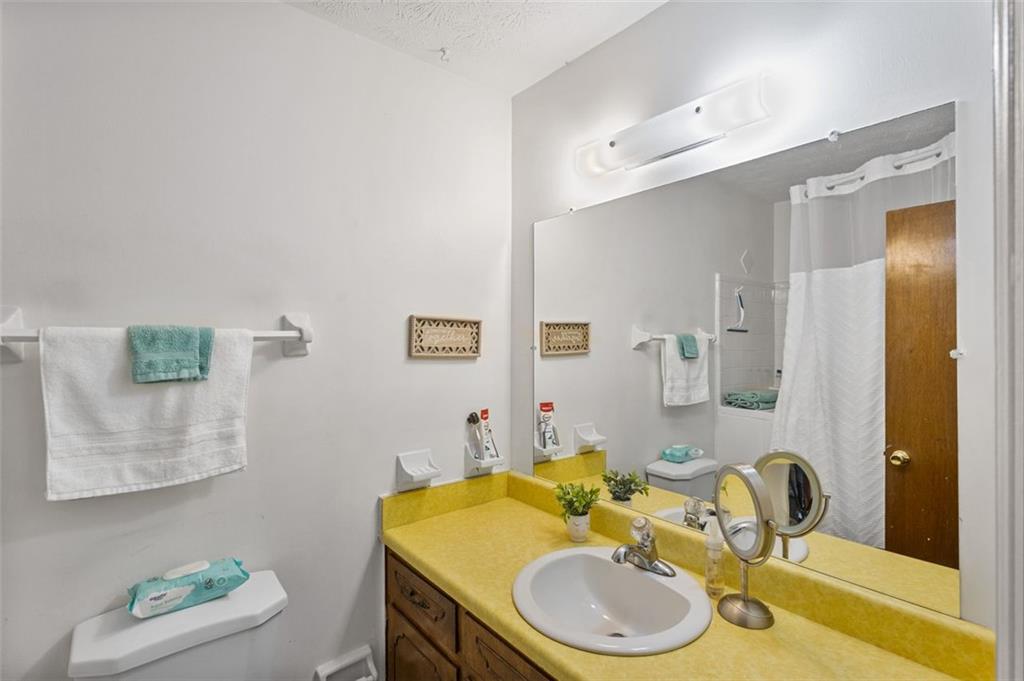 5865 Vernier Drive Southwest Atlanta, GA 30349 - Photo 14 of 33 a bathroom with a granite countertop sink and a mirror