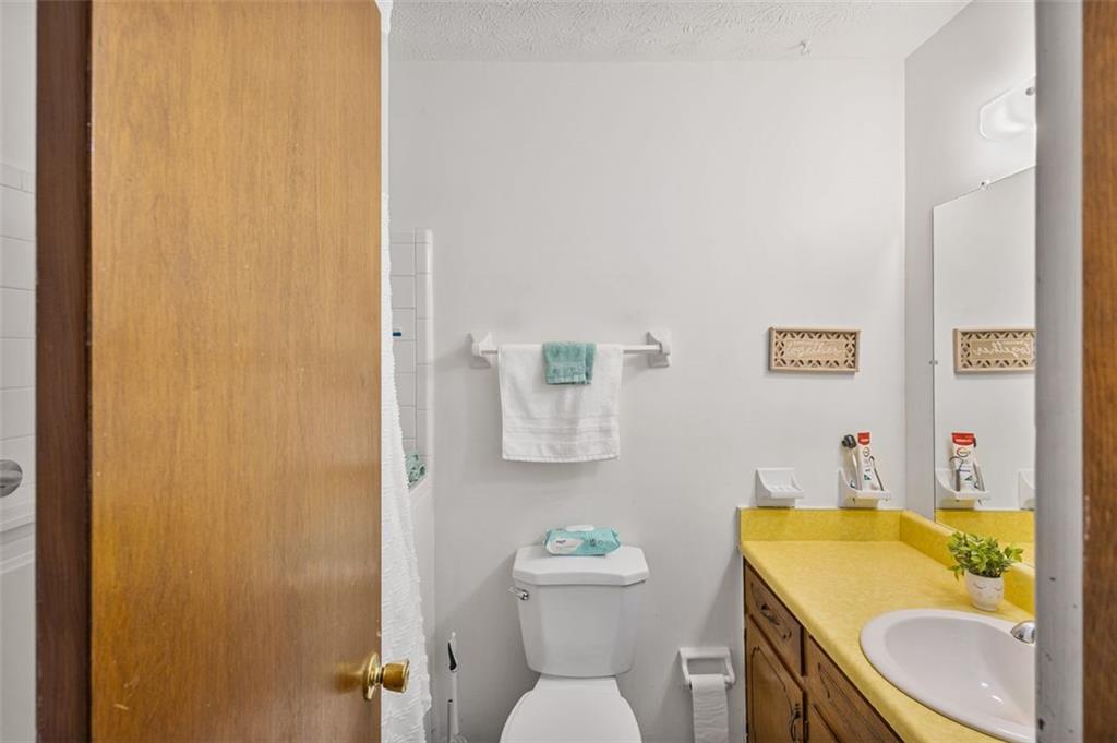 5865 Vernier Drive Southwest Atlanta, GA 30349 - Photo 15 of 33 a bathroom with a sink toilet and mirror