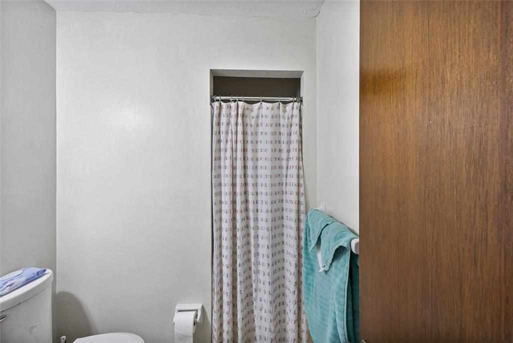 5865 Vernier Drive Southwest Atlanta, GA 30349 - Photo 22 of 33 a bathroom with a toilet and a shower curtain