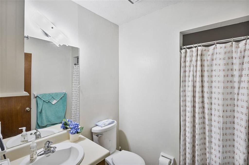 5865 Vernier Drive Southwest Atlanta, GA 30349 - Photo 23 of 33 a bathroom with a sink mirror vanity and toilet